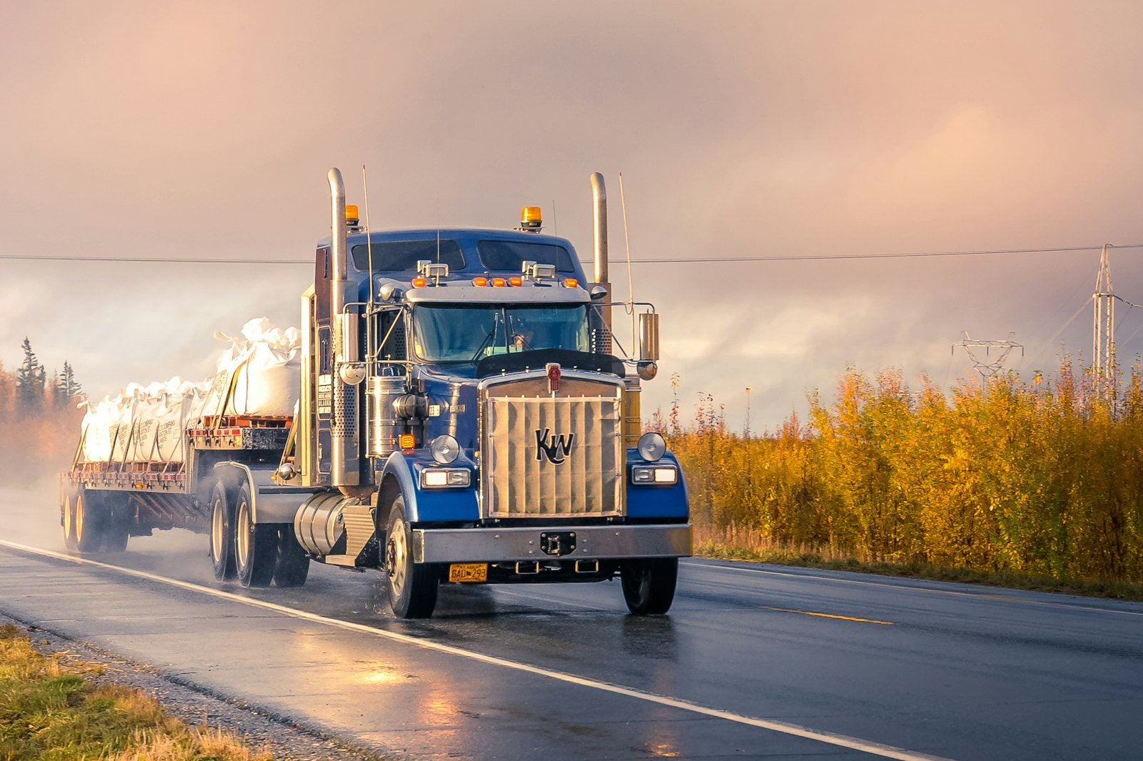 Blue Kenworth semi-truck hauling freight through the Inland Empire, serviced by Quality Truck Repair Inc. in Bloomington, CA