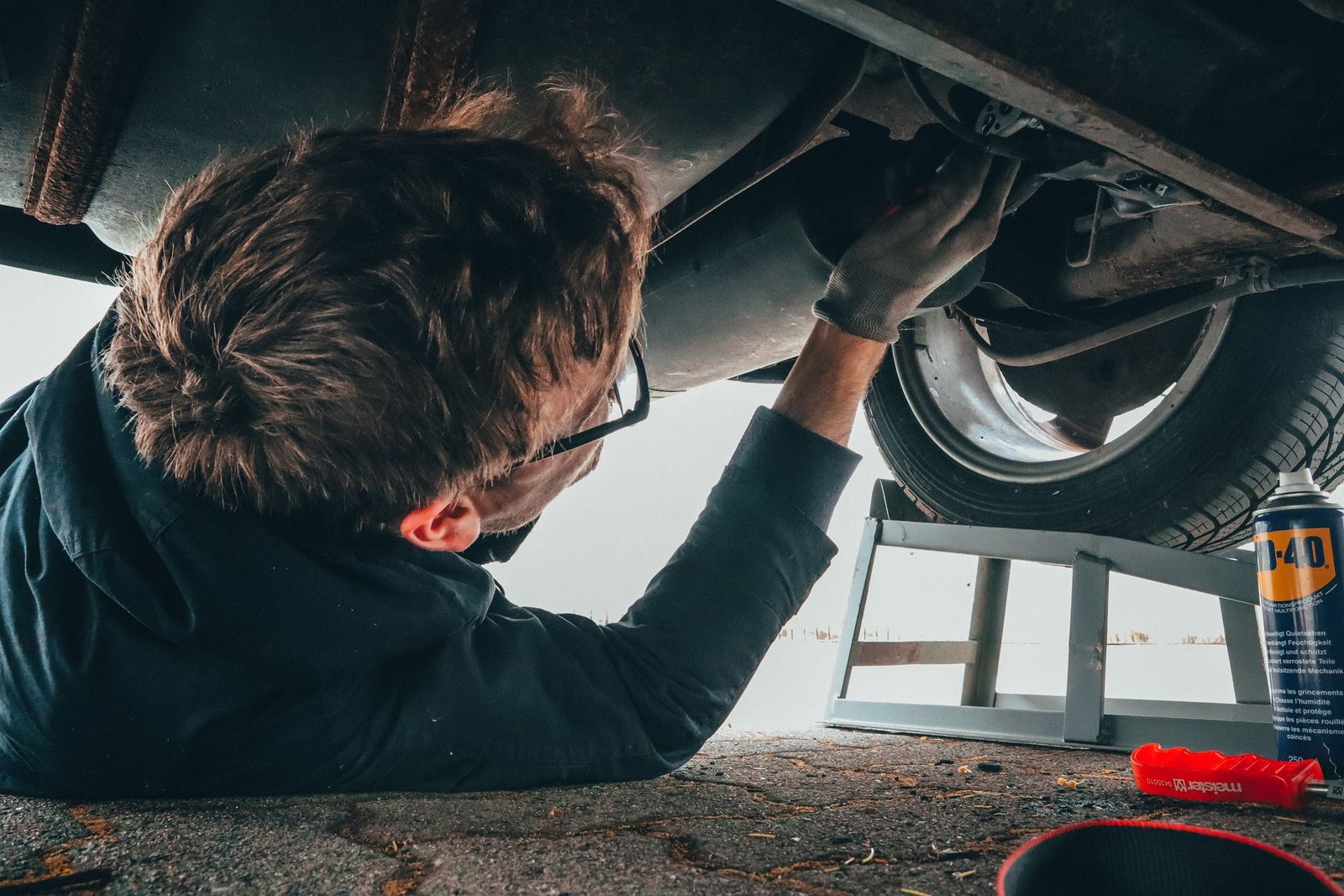 Mechanic working underneath a commercial vehicle during an inspection at Quality Truck Repair Inc. in Bloomington, CA